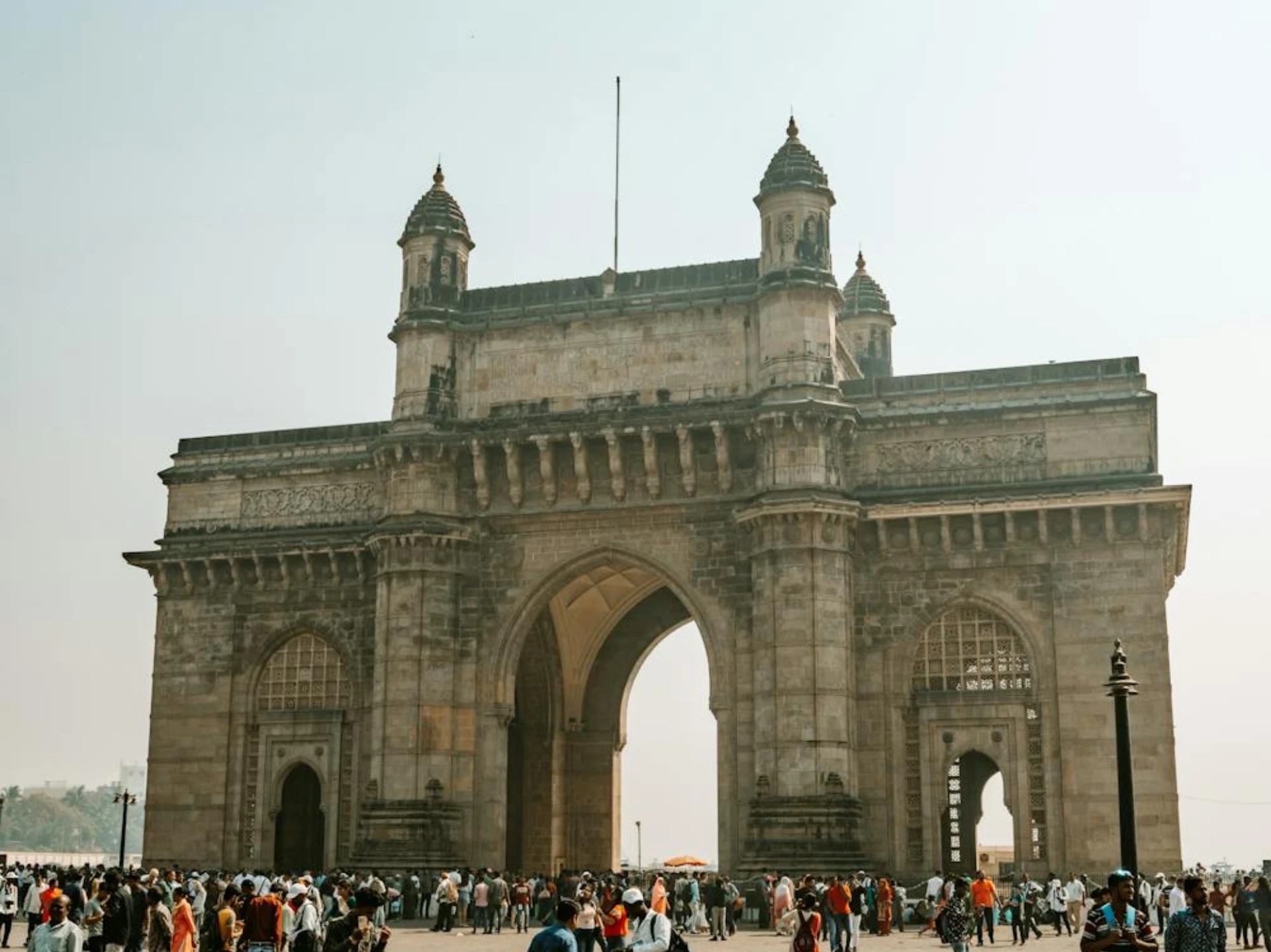 India Gate with a crowd of people gathered in front of it.