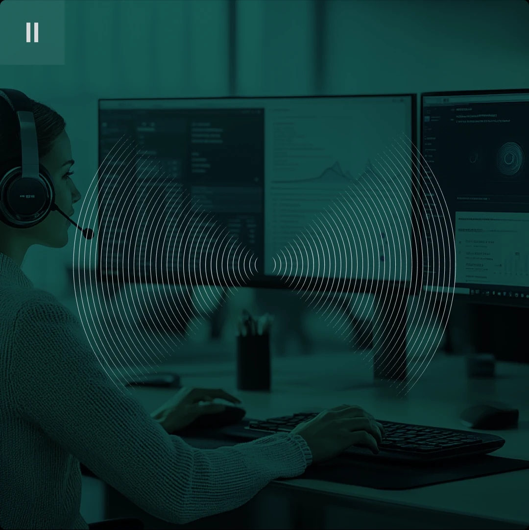 Person wearing a headset working at a computer with dual monitors, overlaid with sound wave graphics.
