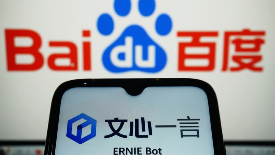 A smartphone screen displaying the ERNIE Bot interface in front of a Baidu logo on a computer monitor.