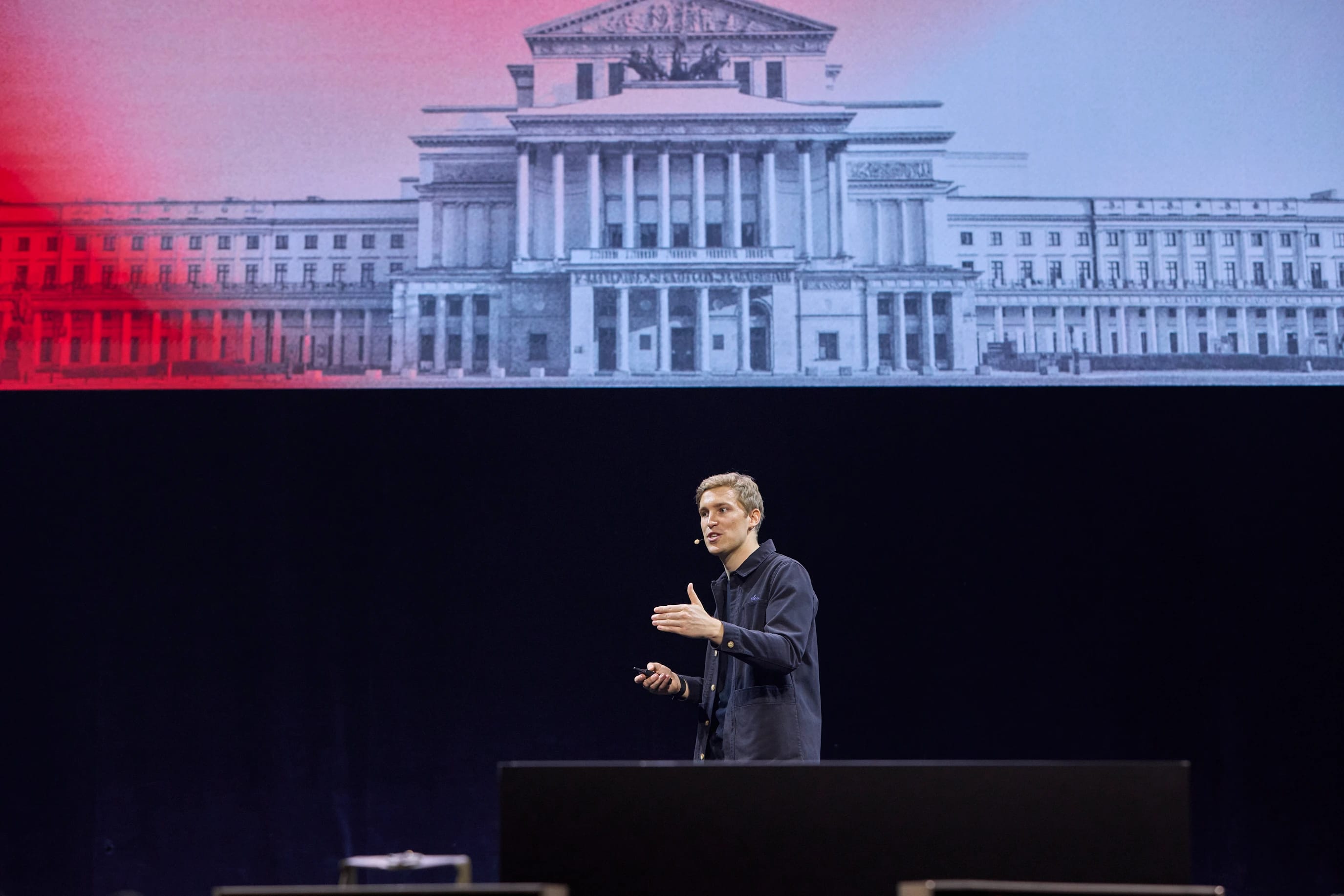 Speaker presents onstage before a projection of the U.S. Supreme Court building.
