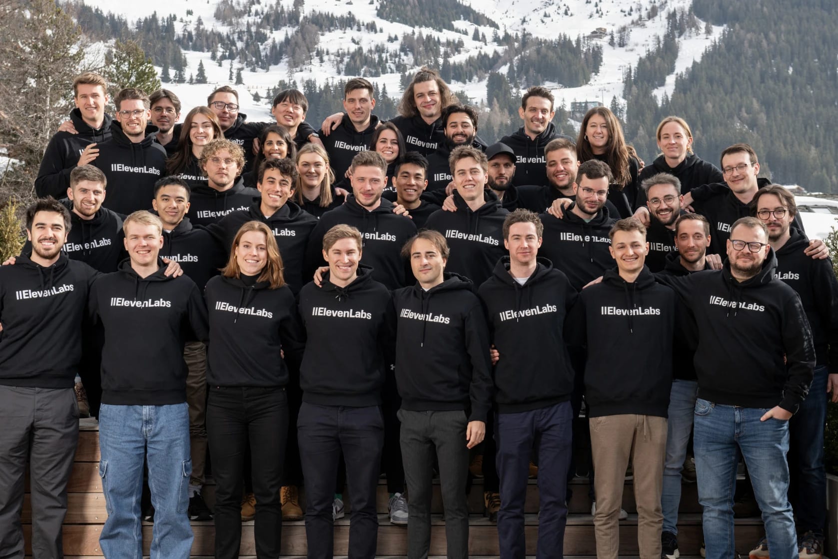 ElevenLabs team members pose together in front of a snowy mountain landscape.